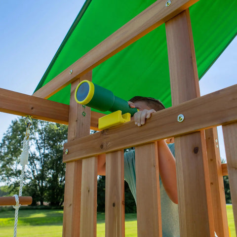 Child using toy telescope on cedar wood swing set with wave slide and elevated play deck. Focus keyword: Cedar Wood Swing Set With Wave Slide And Elevated Play Deck, Double Rock Wall, Rope Ladder, Web Swing And Belt Swings, Toy Telescope, Steering Wheel, Sandbox Area For Backyard Adventure And Kid Approved Outdoor Fun.