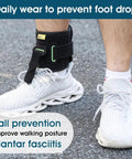 Person wearing Adjustable Drop Foot AFO Brace For Unisex Use, Right Or Left Foot Ortho, on right foot with white sneaker, outdoor use.