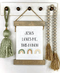 Jesus Loves Me This I Know Hanging Canvas For Kids Boho Rainbow Nursery Decor on wall with green tassel and beads