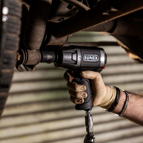 Mechanic using impact wrench with 1/2 Inch Drive Impact Socket Set, 19-Piece SAE, Cr-Mo Alloy Steel attached to vehicle underbody