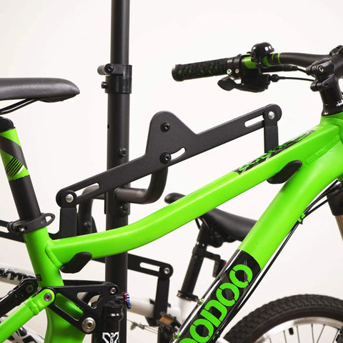 Close-up of Freestanding Four Bike Storage Rack With Adjustable Gravity Hanger holding a green mountain bike securely
