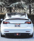 Rear view of a white Tesla with Tesla Model 3 And Model Y Rear License Plate Holder Bracket Frame With Screws Caps And Backseat Air Vent Cover Replacement Kit 109684400B Direct Fit Easy Install Now installed.