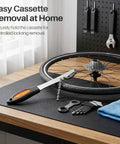 Heavy Duty Chain Whip Bike Tool For Easy Cassette Removal With Non Slip Rubber Grip Handle next to bike wheel and tools