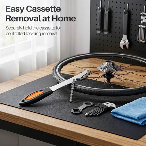 Heavy Duty Chain Whip Bike Tool For Easy Cassette Removal With Non Slip Rubber Grip Handle next to bike wheel and tools