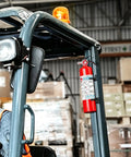 Grab And Dash Two Point Five Lb Multi Purpose Fire Extinguisher mounted on a forklift in a warehouse, ready for emergencies.