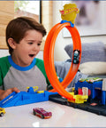 Child playing with Police Station Track Set With Adjustable Loop And Four Lane Race 1:64 Scale Die Cast Vehicle Included Multi Path Stunts