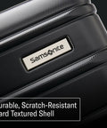 Samsonite Omni 2 hardside luggage close-up of textured black shell with metal logo plate