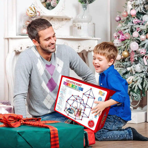 Father and son excitedly holding Creative Fort Building Kit For Kids STEM Construction Toys in festive setting.
