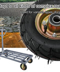 Close-up of heavy duty rubber caster wheel with rugged tread on a gray industrial trolley for work on rough surfaces.