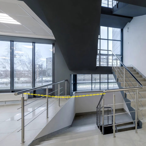 Yellow Plastic Barrier Chain For Safety And Crowd Control, 125 Feet Long And 2 Inches Wide, used to block stair access indoors