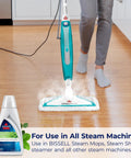 Person using steam mop with Eucalyptus Mint Demineralized Steam Mop Water, 32 Oz, White, Fresh Scent Cleaning Solution For Steam Mops, Model 1392