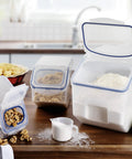 Heavy Duty Bulk Food Storage Containers With Smooth Rolling Wheels And Snap Tight Lids, 50 Cup Dry Goods Pantry Bin With Measuring Cup on kitchen countertop.