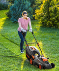 Person using Corded Lawn Mower With 16 Inch Cut And 13 Amp Motor Five Height Settings Easy Vertical Fold Storage Two In One Mulching And Bagging 98 Percent Grass Clippings Collected Ideal For Small To Medium Lawns And Gardens