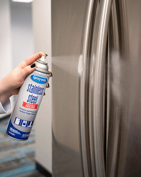 Sprayway stainless steel cleaner and polish aerosol can being sprayed onto a stainless refrigerator door.