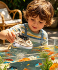Child playing with Wooden Vehicle Model Kit For Hands On Mechanical Engineering Fans over a fish tank