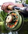 Person fly fishing with Preloaded Sword Fly Fishing Reel With Line CNC Machined Aluminum Alloy 5/6Wt Olive Green on rod.