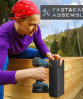 Person assembling a raised garden bed with a Set Of Eight Beefy Raised Garden Bed Corner Brackets With Wood Screws For 20 To 24 Inch Beds Heavy Duty Rust Resistant Metal Connectors 11 By 3 By 3 Inches For Vegetable Planter Garden Durable Easy Assembly Included outdoors.