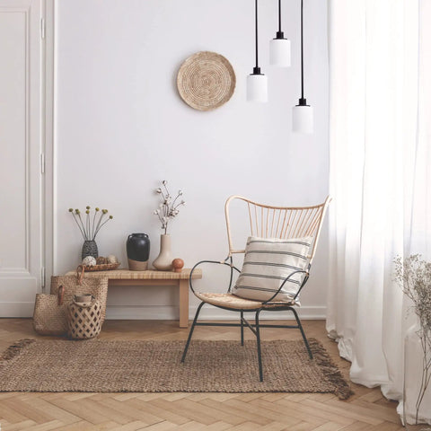 Minimalist room with wicker chair, indoor plants, and pendant lights hanging from ceiling.