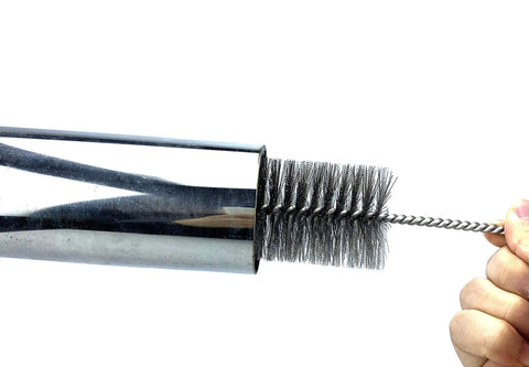 Pipe Cleaning Brush Set With Stainless Steel Bristles being inserted into a metal pipe, showing bristle detail.
