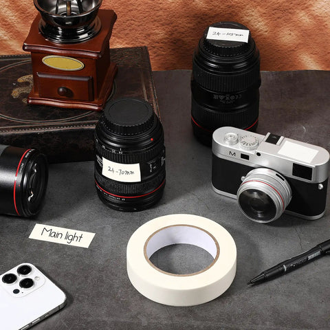 Console Labeling Tape 1 Inch Wide 54.7 Yard Roll Clean Writable Flatback Paper White Adhesive Tape Removable No Residue shown with camera lenses and notes.