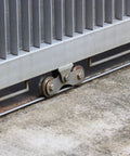 Stainless Steel 2 Pack 1.89 Inch V Groove Track Casters With Double Bearing Rollers Built Tough For Smooth Sliding Gates positioned on a rail.