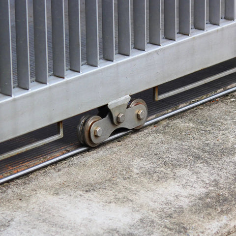 Stainless Steel 2 Pack 1.89 Inch V Groove Track Casters With Double Bearing Rollers Built Tough For Smooth Sliding Gates positioned on a rail.
