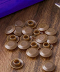 Twenty Piece Light Oak Door Threshold Screw Covers on wood surface, showcasing round plastic caps for fasteners.