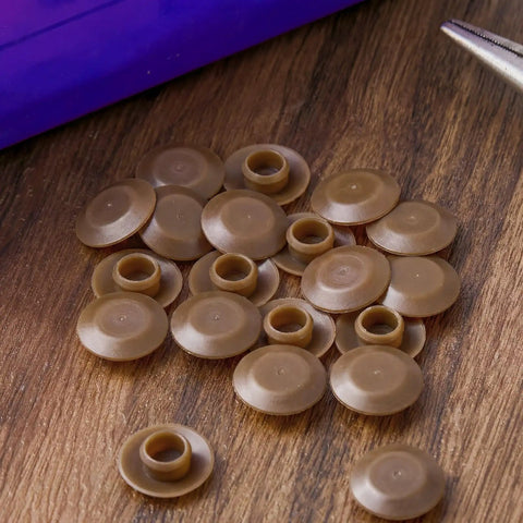 Twenty Piece Light Oak Door Threshold Screw Covers on wood surface, showcasing round plastic caps for fasteners.