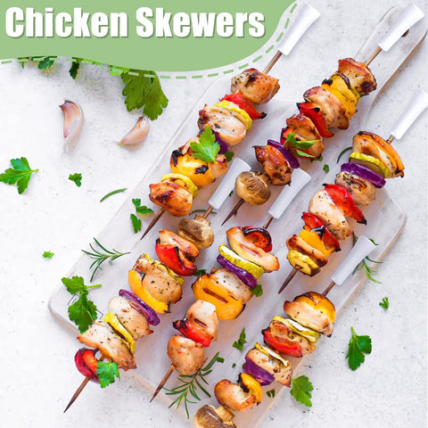 Colorful chicken skewers with vegetables on white background, garnished with herbs.