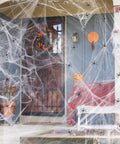 Premium Super Stretchy Halloween Spider Webs Covering 1400 Square Feet With 150 Extra Fake Spiders on a decorated porch.