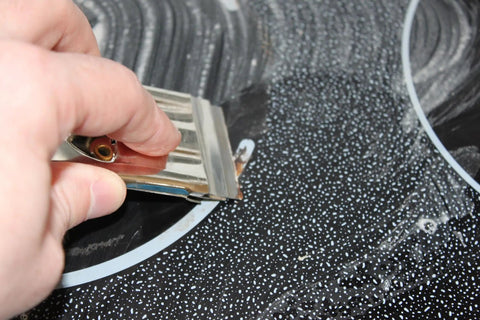 Single Edge Razor Blades 10 Pack For Straight Edge Razors And Scrapers in use on a dark speckled surface.