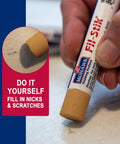 Light Golden Oak Wood Repair Wax Putty Stick For Scratches And Gouges used to fill nicks while applying on a white surface.