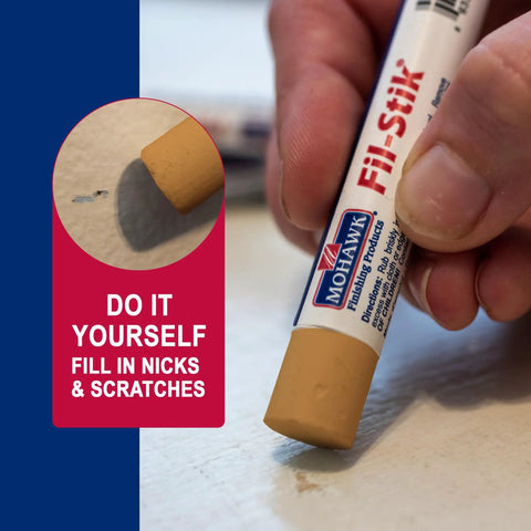 Light Golden Oak Wood Repair Wax Putty Stick For Scratches And Gouges used to fill nicks while applying on a white surface.