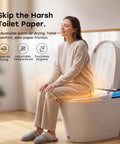Woman using a sleek sensor activated smart toilet with built in bidet pump and self cleaning deodorizer featuring heated seat.