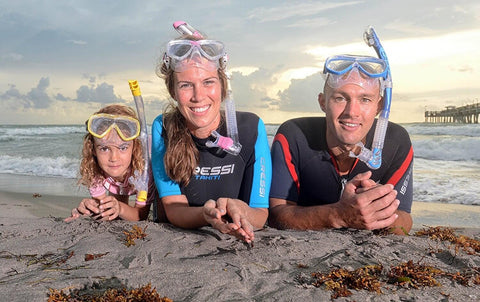 Group on a beach wearing Dry Top Snorkel With Instant Float Closure No Fuss Anti Splash Snorkel Gear For Water Free Breathing in black and blue finish.