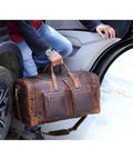 Man lifting 32 Inch Vintage Duffel Bag With Old School Look And Modern Touch Handmade Full Grain Buffalo Leather Carry On Fits Under Seat