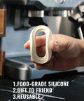 Hand holding 58mm Silicone Steam Ring Set Of 2 for Breville and Sage espresso machines BES900XL BES920XL in front of machine