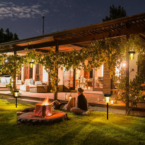 Night scene with Solar Pathway Lights 4 Pack Outdoor IP65 Waterproof Garden Lights illuminating yard near patio with fire pit