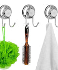 Powerful Vacuum Suction Cup Hooks for Shower and Bathroom on Flat Smooth Surfaces Like Ceramic Tile Glass Mirror Granite and Stainless Steel NeverRust Black 4 Pack Great for Towels Robes and Coats with Strong Hold and Easy Non Marking Installation holding a bath sponge, brush, and towel