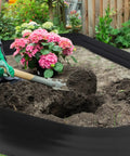 Gardener using spade with 8 Inch Tall 33 Ft Garden Landscape Edging Kit Black Plastic Border for Lawn and Flower Beds