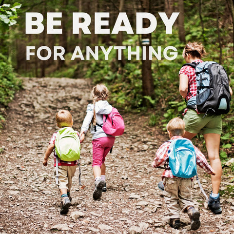 Kids' travel first-aid kit concept: family hiking in a forest with colorful backpacks