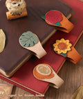 4 Piece Vintage Magnetic Leather Bookmarks With Retro PU Clip, Legit Game Changer For Reading Stacks shown atop books.