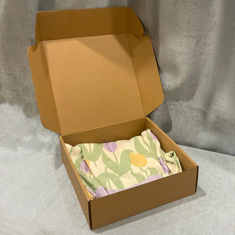Heavy Duty 20 Pack Of 10X10X3 Inch Brown Corrugated Cardboard Shipping Boxes With Smooth Finish Edges for mailing with a cloth inside.