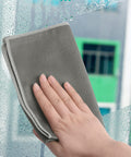 Hand using grey Fish Scale Microfiber Cleaning Cloths For Glass And Mirrors, Window And Car Surfaces, Eyeglass Lenses, 16x16 Inch