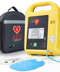 AED defibrillator home portable device in yellow case with black Amazon-branded carry bag and defibrillator pads.