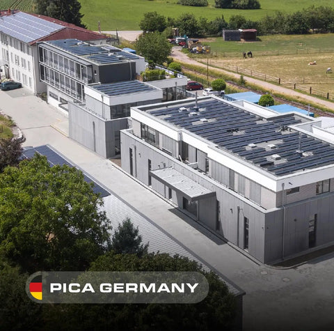 Aerial view of Pica Germany office buildings with solar panels and surrounding greenery.