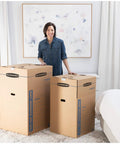 Heavy Duty Tape Free Wardrobe Moving Boxes 3 Pack With Sturdy Hanging Rail And Grippy Handles in a bedroom setting.