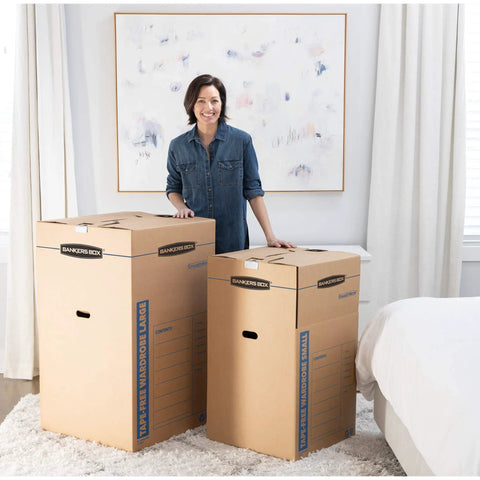 Heavy Duty Tape Free Wardrobe Moving Boxes 3 Pack With Sturdy Hanging Rail And Grippy Handles in a bedroom setting.