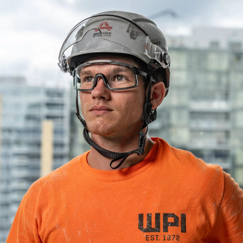 Premium Safety Glasses With Ansi Z87 Plus Impact Rating Featuring Anti Fog Vented Polycarbonate Lenses worn by a worker in an orange shirt.
