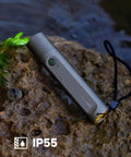 Tiny But Mighty LED Flashlight Rechargeable USB C lying on wet rock, IP55 waterproof, outdoors setting for camping and hiking.